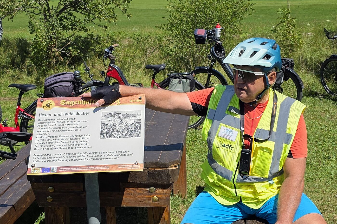Tourguide sitzt neben Schild