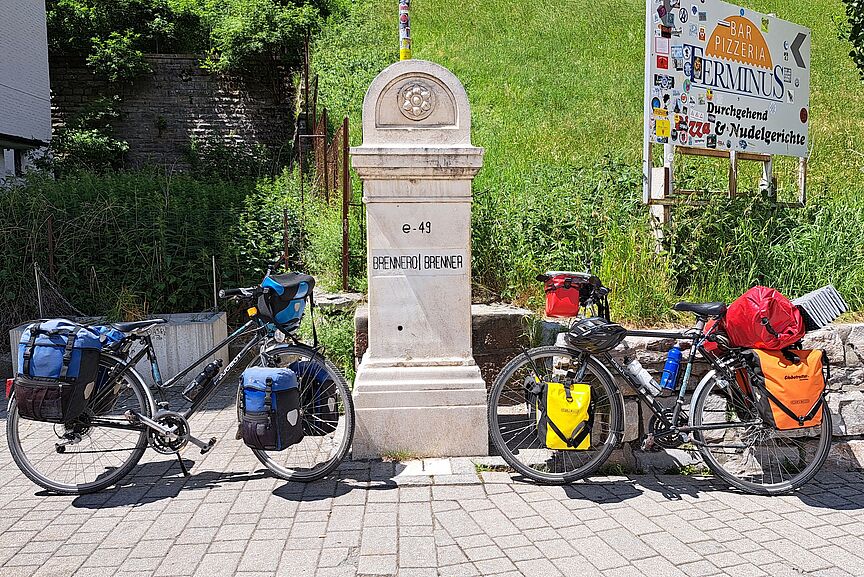 Vortrag Italien Zwei Reiseräder vor Grenzstein