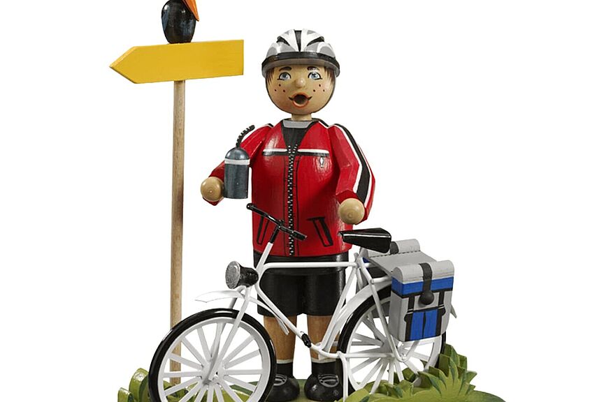 Symbol_Radfahrerin Käthe-Wohlfahrt-Figur eines Radfahrers auf Tour mit Wegweiser