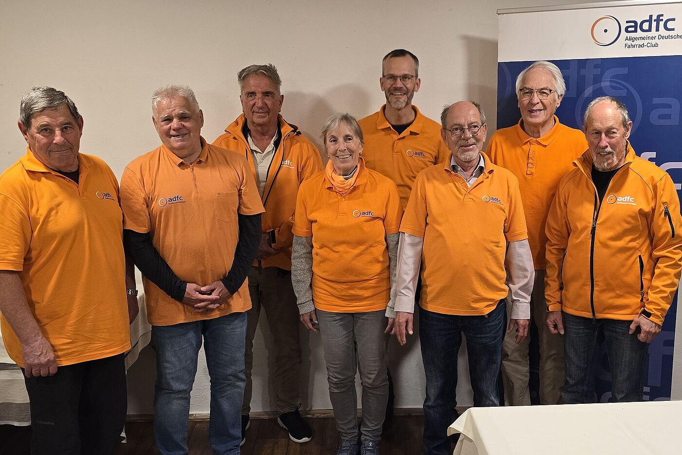 Menschen mit orangenen Oberteilen