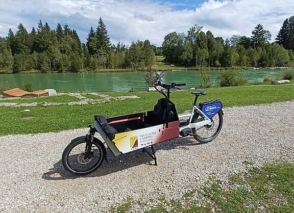 Lastenrad am Weg. Fluss im Hintergrund