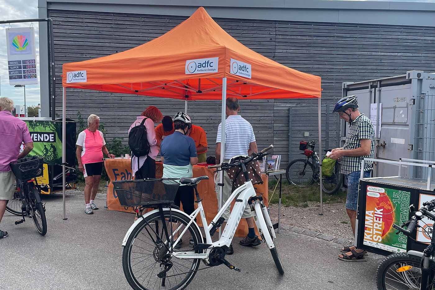 orangener Pavillon mit Personen und Fahrrad