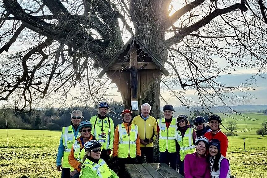 Teilnehmer Menschen in einer Sitzgruppe vor einem Kreuz
