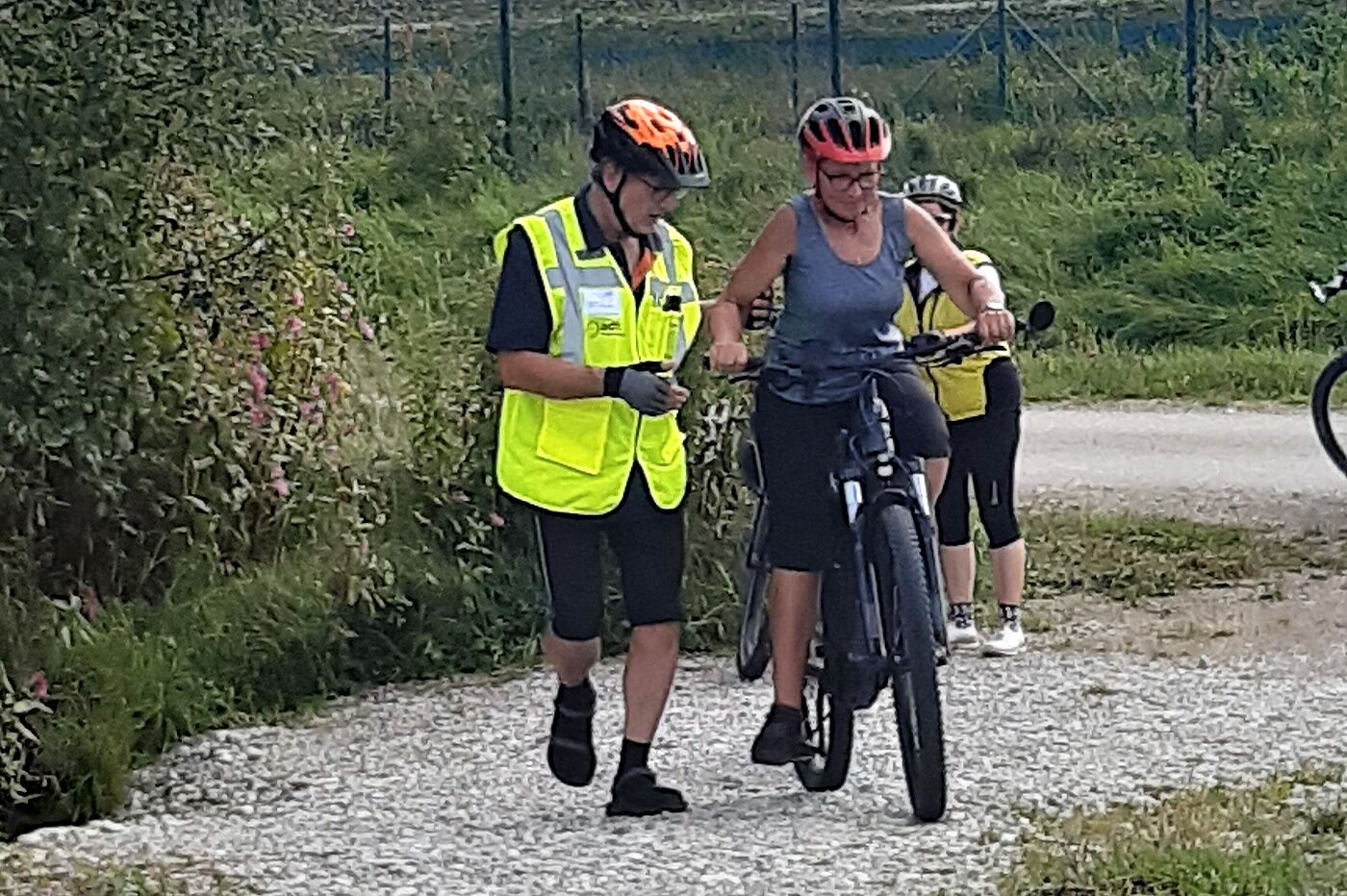 Radfahrerin auf Schotter mit Hilfestellung