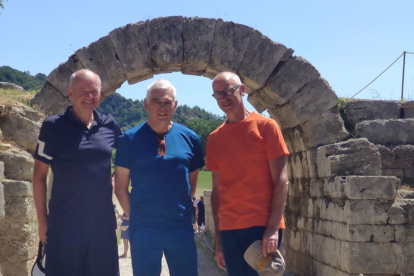 3 Radler vor Steinbogen