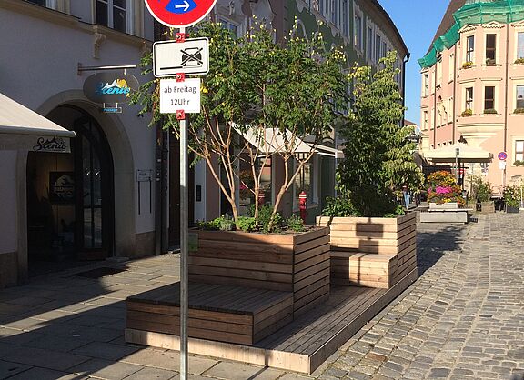 Sitzkisten aus Holz mit Pflanzen in der Innenstadt