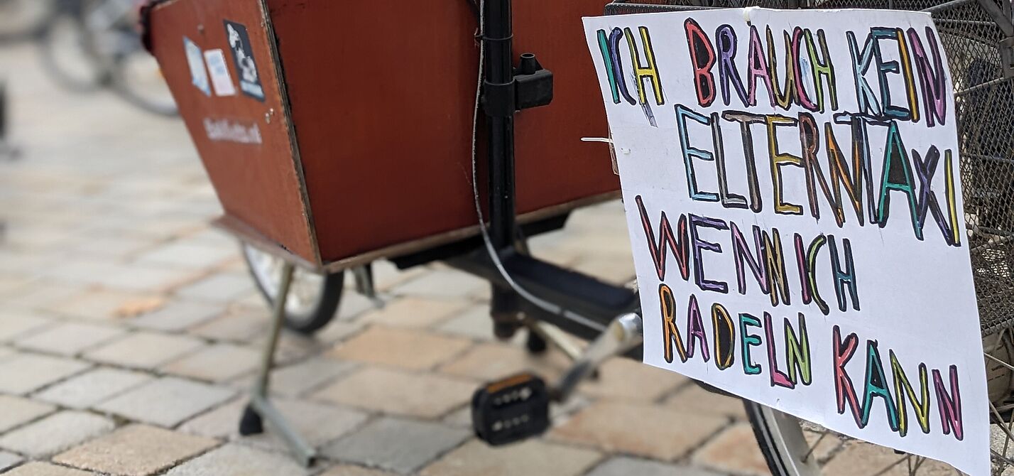 KM MOD Elternprotest Lastenrad mit Demonstrationsplakat