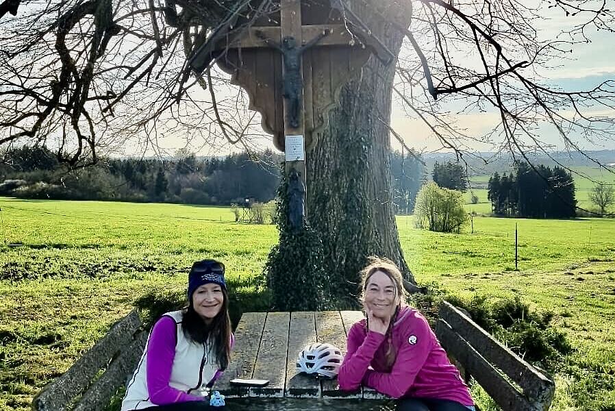 zwei Frauen vor Kreuz und Baum