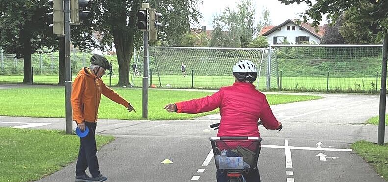 Radfahrerin beim Linksabbiegen mit Trainer