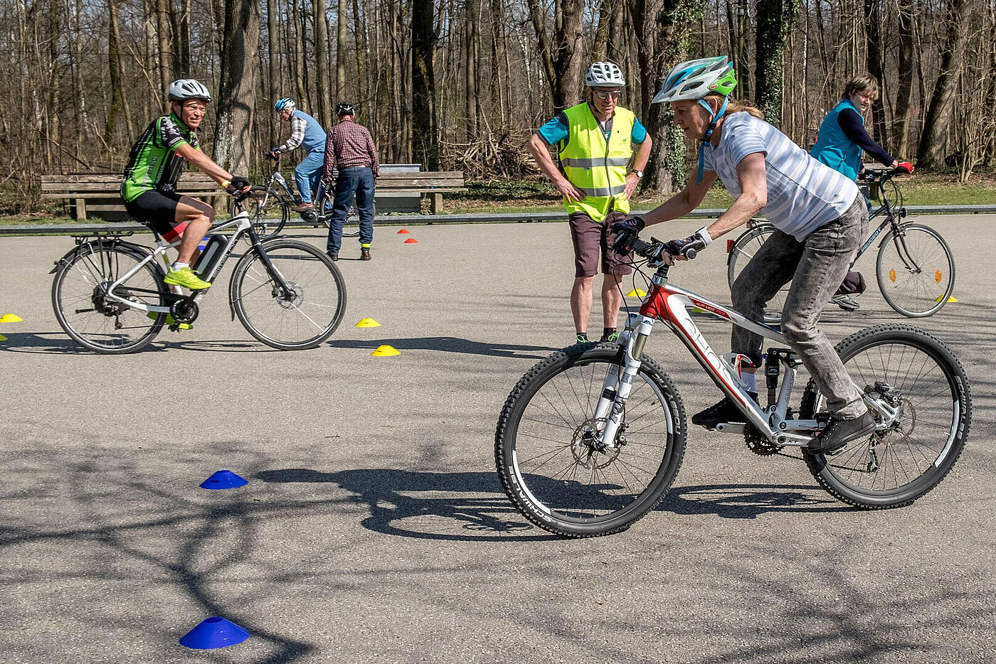 Erwachsene Radfaher:innen üben Radfahren unter Anleitung