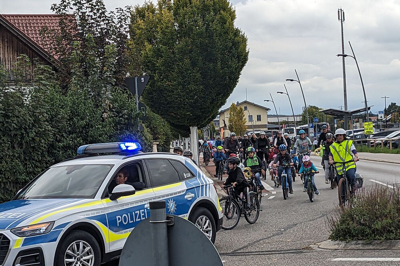 Polizeiauto fährt vor demonstrierenden Radlern