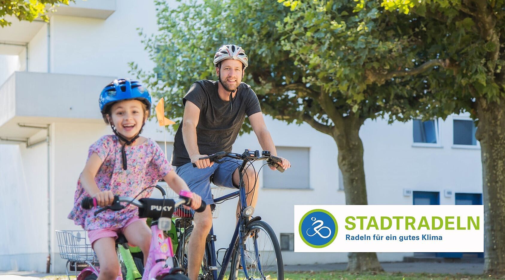 Vater und Kind radeln im Park