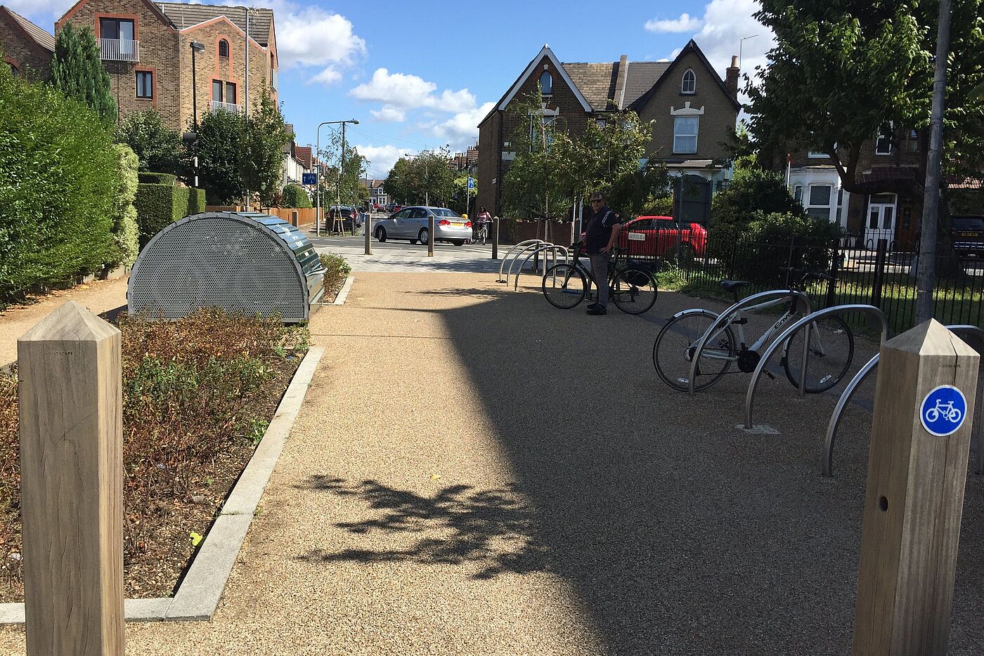 Mini-Hollands in London: Grün- und Flanierfläche mit Fahrradparkplätzen.